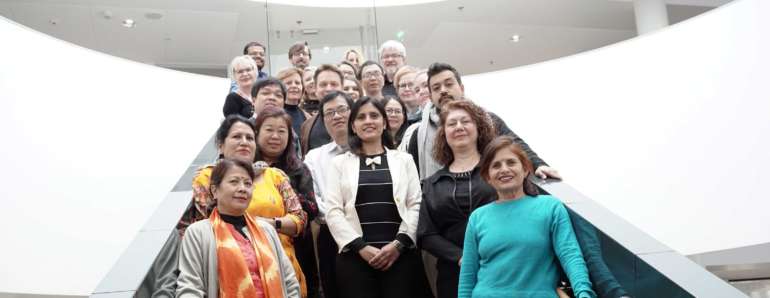 A large group of people working in the DVINE project standing on a stairs.