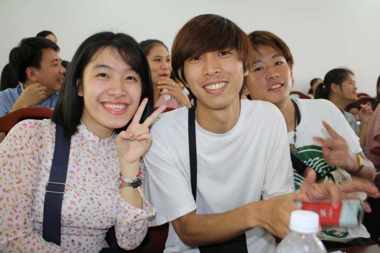 Smiling young students in a classroom in Vietnam.