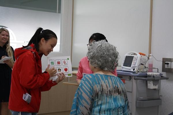 A young female is showing a picture to an elderly person.