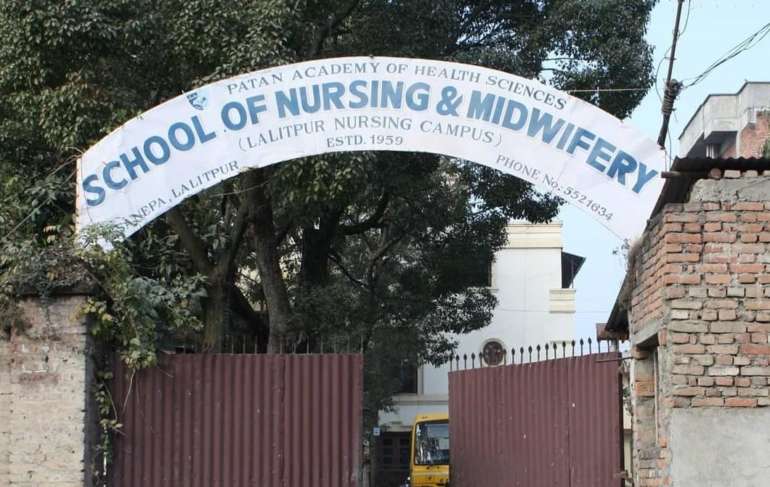 A gate and sign of "School of Nursing and Midwifery" in Lalithpur, Nepal.