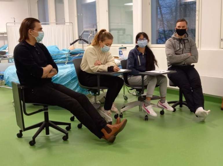 4 student sit in a row in simulation classwith masks on their face