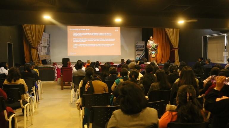 people sitting in a conference hall and following a presentation